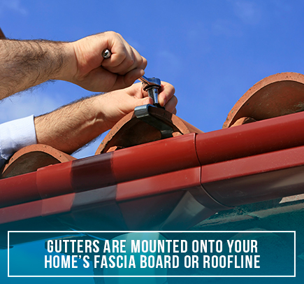 A Person Fastening a Gutter to the Roof of a House