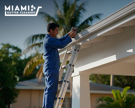 A technician using a digital measuring tool along the roofline of a clean Miami home, with transparent cost calculation overlay graphics showing linear foot estimates.